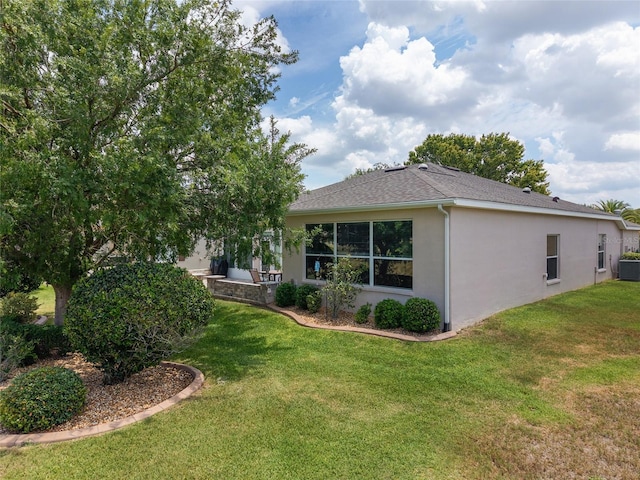 1748 SW 157th Place Rd, Ocala, FL 34473 - back of house featuring stucco siding, a yard, cooling unit, and a shingled roof