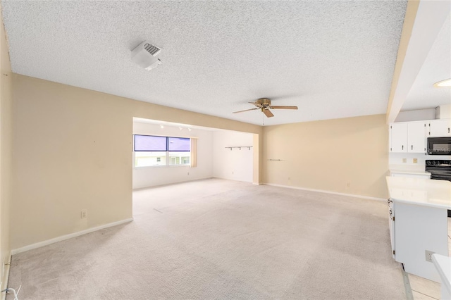 8885 SW 90th Ave, Ocala, FL 34481 - unfurnished living room featuring a ceiling fan, light colored carpet, a textured ceiling, and baseboards