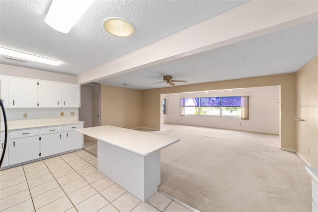 8885 SW 90th Ave, Ocala, FL 34481 - kitchen with a textured ceiling, light countertops, white cabinetry, open floor plan, and light tile patterned floors