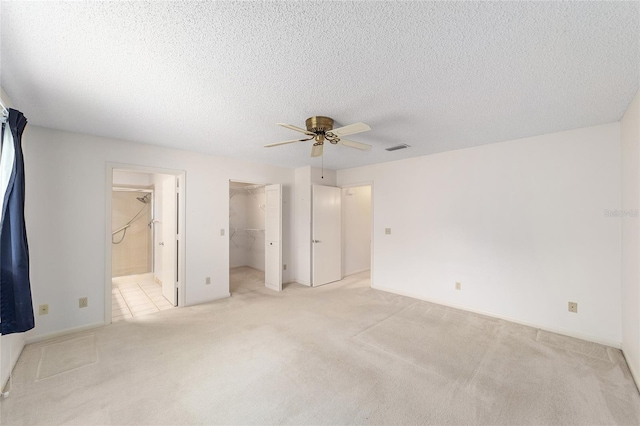 8885 SW 90th Ave, Ocala, FL 34481 - unfurnished bedroom with light colored carpet, ensuite bath, a spacious closet, a textured ceiling, and a ceiling fan