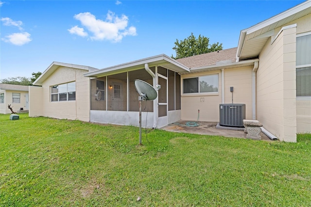 8885 SW 90th Ave, Ocala, FL 34481 - rear view of house featuring central air condition unit, a sunroom, and a lawn