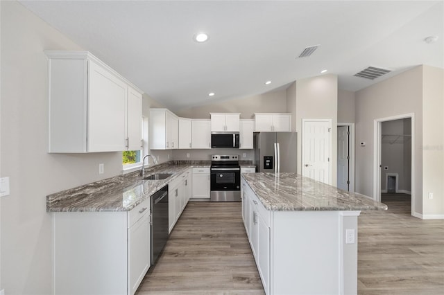 10158 N Carib Way, Citrus Springs, FL 34434 - kitchen featuring stainless steel appliances, a kitchen island, light stone counters, white cabinets, and vaulted ceiling