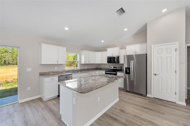10158 N Carib Way, Citrus Springs, FL 34434 - kitchen with stainless steel appliances, vaulted ceiling, light stone counters, light wood-style flooring, and white cabinets