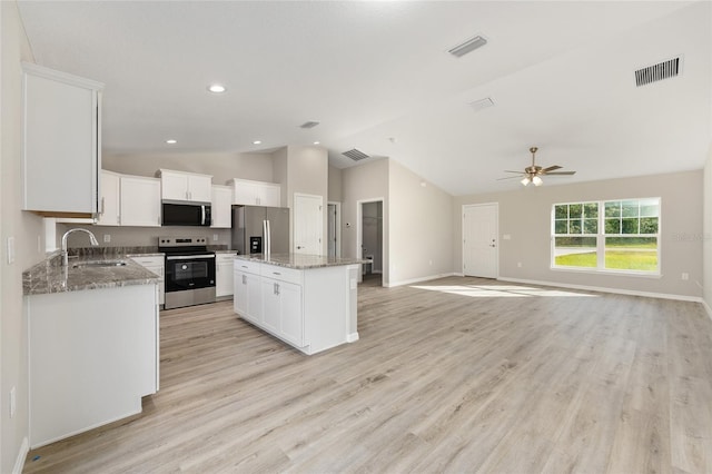 10158 N Carib Way, Citrus Springs, FL 34434 - kitchen with stainless steel appliances, vaulted ceiling, a center island, a ceiling fan, and white cabinets