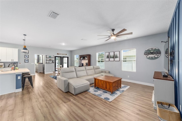 7479 SW 130th Ln, Ocala, FL 34473 - living area featuring light wood-style flooring, a ceiling fan, plenty of natural light, and a textured ceiling