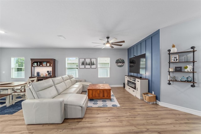 7479 SW 130th Ln, Ocala, FL 34473 - living room featuring a ceiling fan, plenty of natural light, and light wood-style flooring