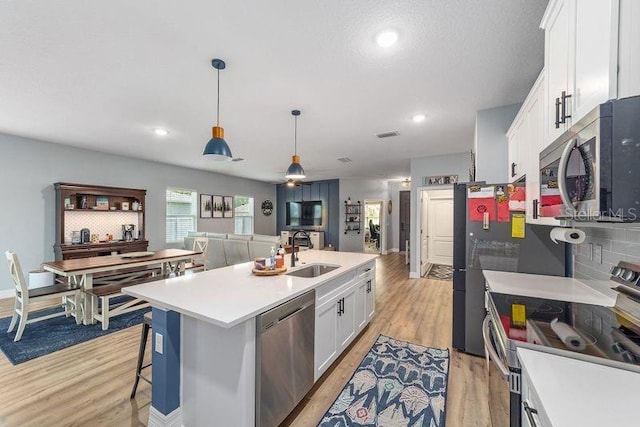 7479 SW 130th Ln, Ocala, FL 34473 - kitchen featuring appliances with stainless steel finishes, a sink, white cabinets, light wood-style floors, and recessed lighting