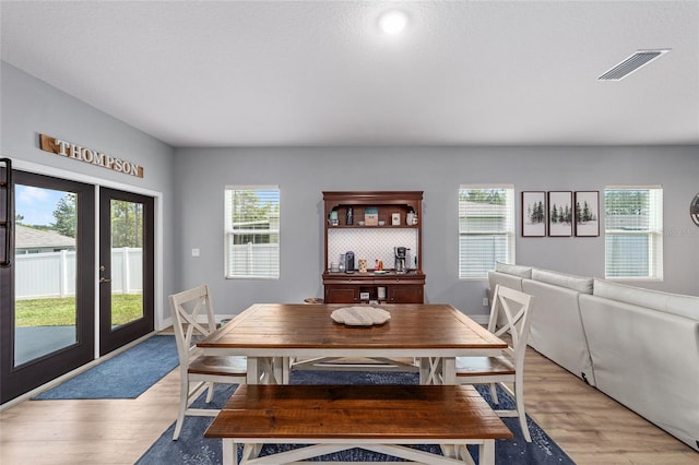 7479 SW 130th Ln, Ocala, FL 34473 - dining area with light wood finished floors, plenty of natural light, and french doors