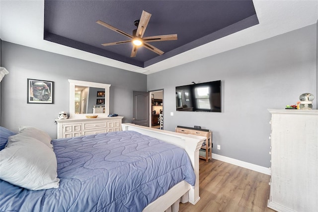 7479 SW 130th Ln, Ocala, FL 34473 - bedroom with a raised ceiling, wood finished floors, baseboards, and a ceiling fan
