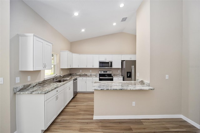 12505 SW 73rd St, Ocala, FL 34481 - kitchen with appliances with stainless steel finishes, a sink, light stone countertops, high vaulted ceiling, and white cabinetry