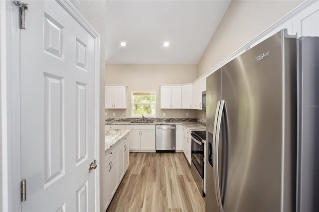 12505 SW 73rd St, Ocala, FL 34481 - kitchen with stainless steel appliances, light wood-style flooring, white cabinetry, a sink, and light stone countertops