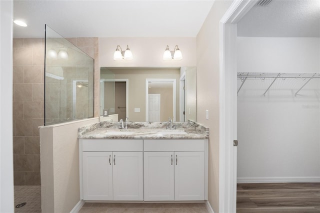 12505 SW 73rd St, Ocala, FL 34481 - full bathroom with double vanity, walk in shower, baseboards, a spacious closet, and wood finished floors