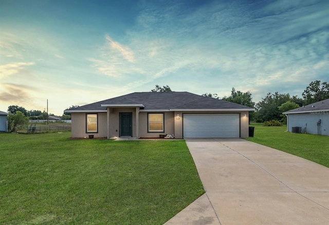 6561 SW 129th Loop, Ocala, FL 34473 - ranch-style home with driveway, a yard, an attached garage, stucco siding, and central AC unit