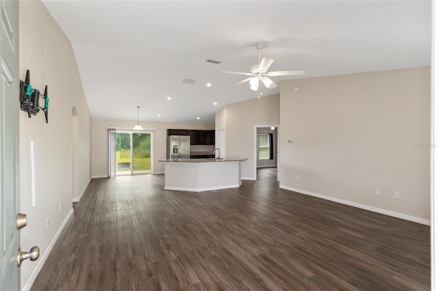 6561 SW 129th Loop, Ocala, FL 34473 - unfurnished living room with arched walkways, ceiling fan, baseboards, dark wood-style flooring, and high vaulted ceiling
