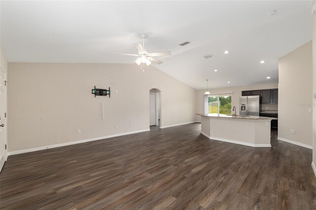 6561 SW 129th Loop, Ocala, FL 34473 - unfurnished living room featuring arched walkways, a sink, dark wood-type flooring, a ceiling fan, and lofted ceiling