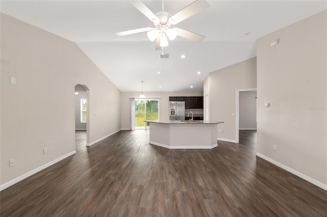 6561 SW 129th Loop, Ocala, FL 34473 - unfurnished living room with vaulted ceiling, a ceiling fan, a sink, arched walkways, and baseboards