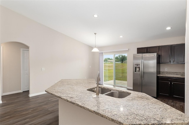 6561 SW 129th Loop, Ocala, FL 34473 - kitchen featuring stainless steel fridge, a sink, arched walkways, dark wood-style floors, and a center island with sink