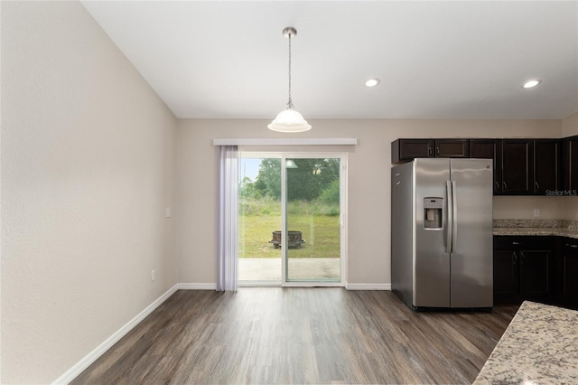 6561 SW 129th Loop, Ocala, FL 34473 - kitchen with stainless steel fridge with ice dispenser, dark wood finished floors, baseboards, decorative light fixtures, and light stone countertops
