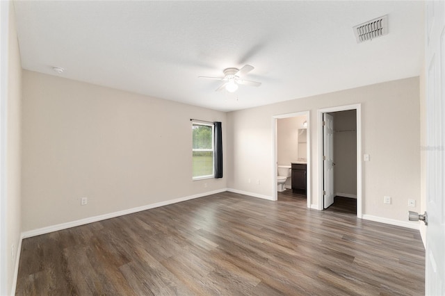 6561 SW 129th Loop, Ocala, FL 34473 - unfurnished bedroom with dark wood-type flooring, baseboards, a spacious closet, and ensuite bath