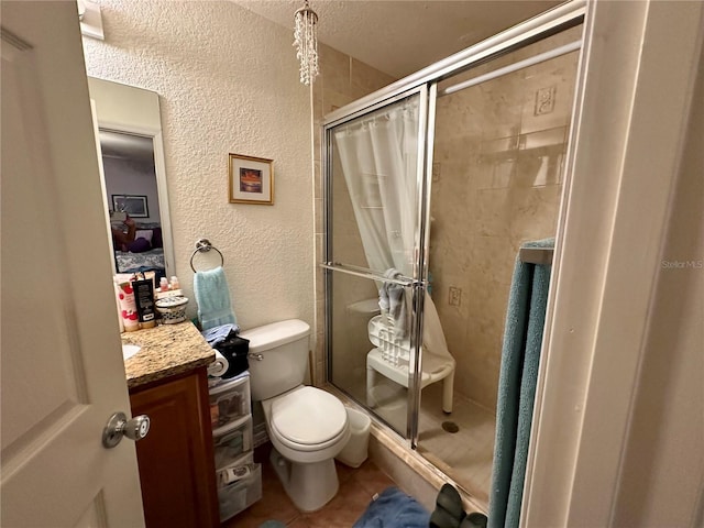 27 Cedar Tree Ter, Ocala, FL 34472 - bathroom with a stall shower, toilet, vanity, a textured wall, and tile patterned floors