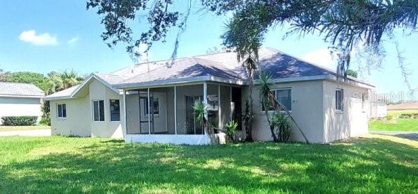 5110 NW 19th Pl, Ocala, FL 34482 - back of property featuring a sunroom, a yard, and stucco siding