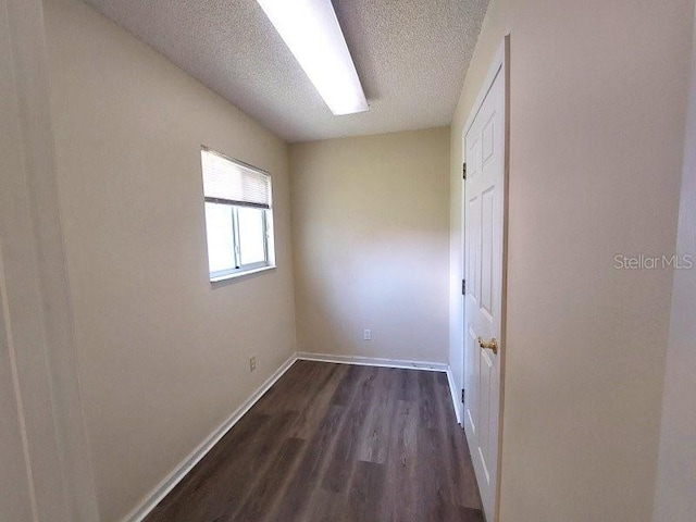 5110 NW 19th Pl, Ocala, FL 34482 - empty room featuring dark wood-type flooring, a textured ceiling, and baseboards