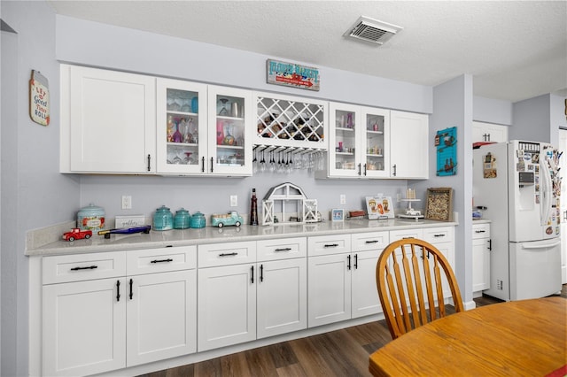 6070 SE 39th Ave, Ocala, FL 34480 - kitchen featuring white refrigerator with ice dispenser, light countertops, white cabinetry, dark wood finished floors, and glass insert cabinets