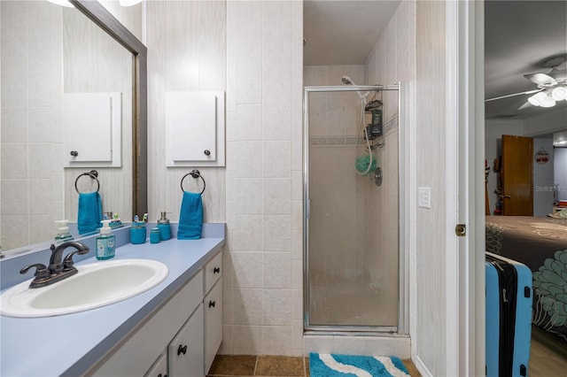 6070 SE 39th Ave, Ocala, FL 34480 - ensuite bathroom with a shower stall, vanity, a ceiling fan, and tile walls