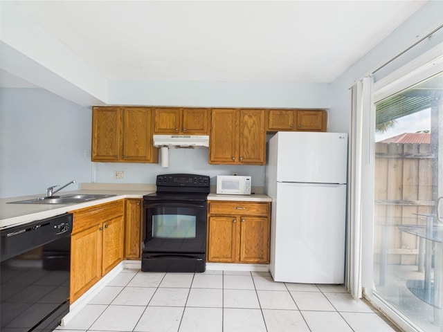 1801 Caralee Blvd Unit 2, Orlando, FL 32822 - kitchen with black appliances, under cabinet range hood, light countertops, and brown cabinets
