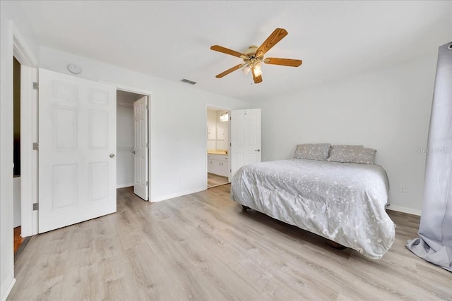 6350 NW 135th Ave, Morriston, FL 32668 - bedroom with light wood finished floors, a spacious closet, ensuite bathroom, and baseboards