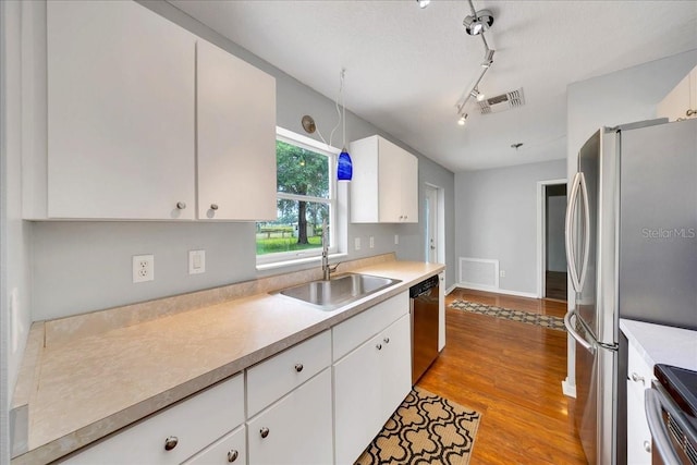 6350 NW 135th Ave, Morriston, FL 32668 - kitchen featuring appliances with stainless steel finishes, a sink, light countertops, and white cabinets