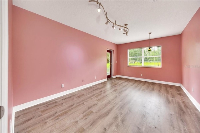 6350 NW 135th Ave, Morriston, FL 32668 - empty room featuring wood finished floors, baseboards, and a textured ceiling