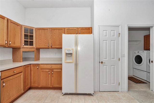11062 SW 73rd Ct, Ocala, FL 34476 - kitchen with white fridge with ice dispenser, independent washer and dryer, light tile patterned floors, light countertops, and glass insert cabinets