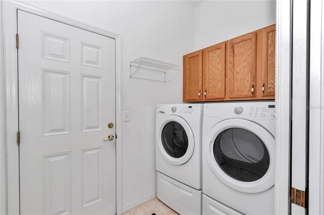11062 SW 73rd Ct, Ocala, FL 34476 - washroom featuring independent washer and dryer, cabinet space, and light tile patterned floors