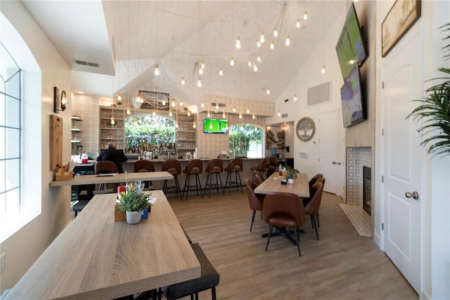 11062 SW 73rd Ct, Ocala, FL 34476 - dining space featuring a glass covered fireplace, high vaulted ceiling, and wood finished floors