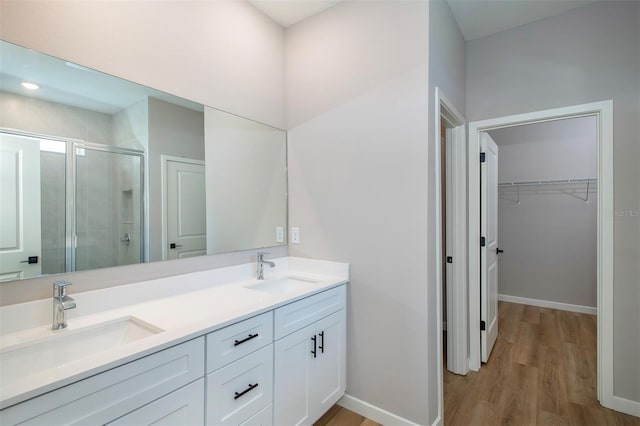 10207 SW 41st Ter W, Ocala, FL 34476 - full bathroom with a stall shower, double vanity, wood finished floors, and a spacious closet