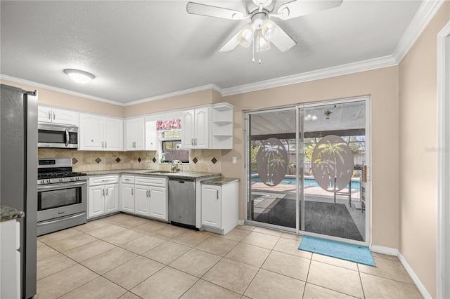 5720 SE 20th St, Ocala, FL 34480 - kitchen with stainless steel appliances, white cabinets, open shelves, a sink, and decorative backsplash