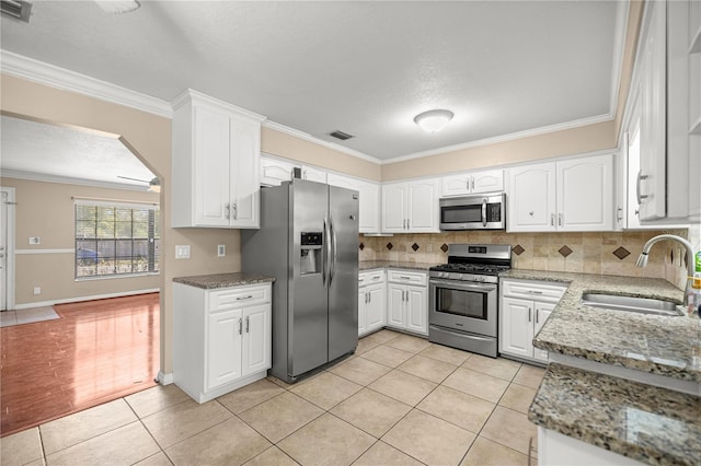 5720 SE 20th St, Ocala, FL 34480 - kitchen with stainless steel appliances, a sink, light tile patterned floors, crown molding, and tasteful backsplash