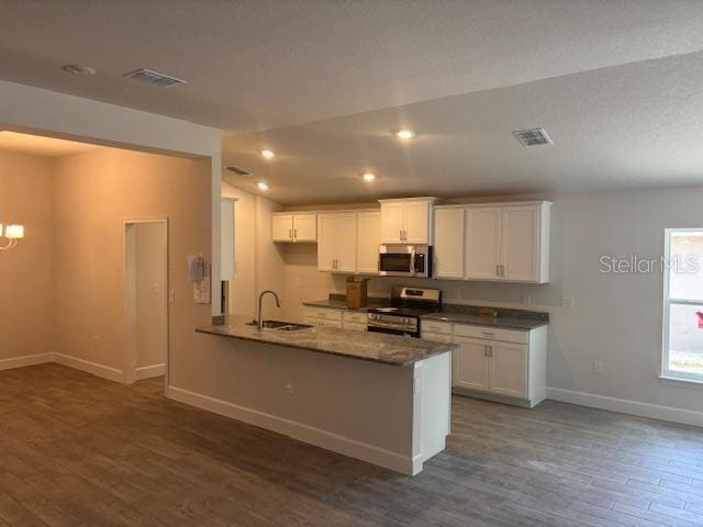 7637 SW 180th Cir, Dunnellon, FL 34432 - kitchen featuring appliances with stainless steel finishes, a sink, baseboards, dark wood-type flooring, and white cabinetry