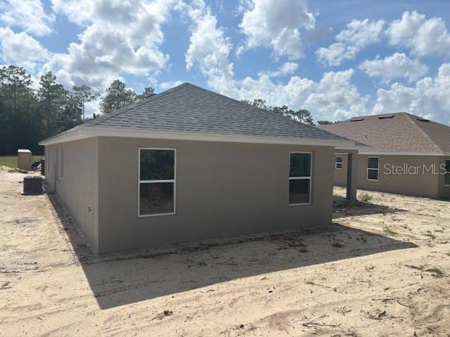 7637 SW 180th Cir, Dunnellon, FL 34432 - rear view of house featuring a shingled roof and stucco siding