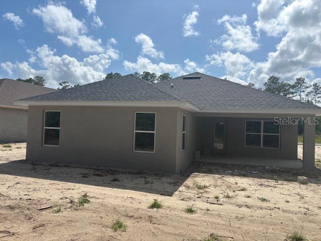 7637 SW 180th Cir, Dunnellon, FL 34432 - rear view of property with a shingled roof, a patio area, and stucco siding