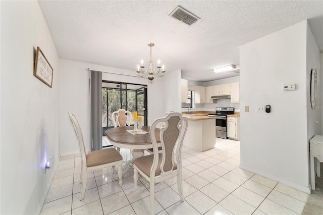 2701 NE 10th St Unit 101, Ocala, FL 34470 - dining room with a chandelier, baseboards, light tile patterned flooring, and a textured ceiling