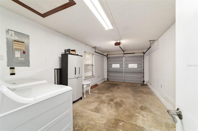 2701 NE 10th St Unit 101, Ocala, FL 34470 - garage featuring electric panel, freestanding refrigerator, a garage door opener, baseboards, and washer and dryer