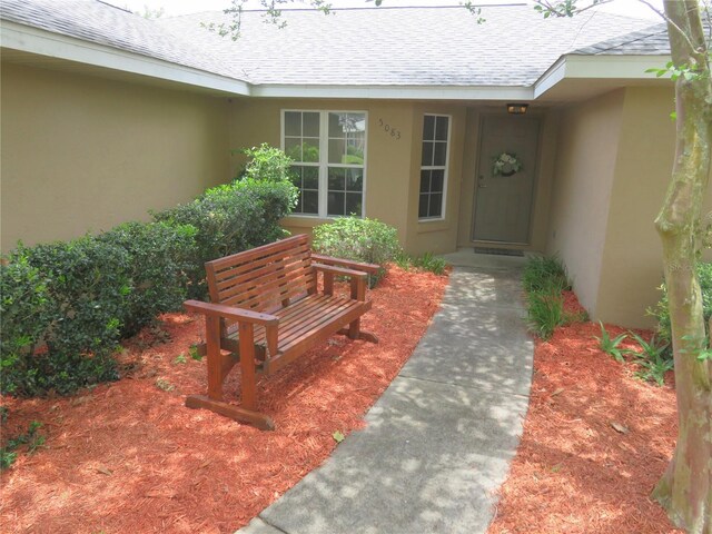 5083 SE 26th St, Ocala, FL 34480 - view of exterior entry with a shingled roof and stucco siding
