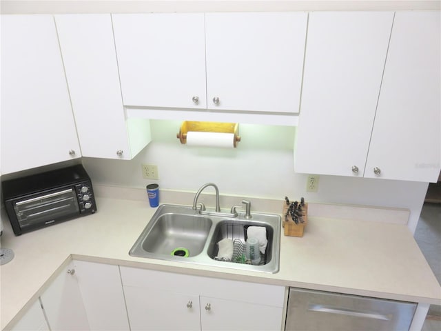 5083 SE 26th St, Ocala, FL 34480 - kitchen featuring white cabinetry, light countertops, stainless steel dishwasher, and a sink