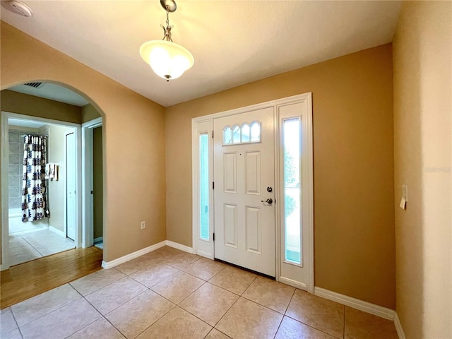16405 SW 14th Avenue Rd, Ocala, FL 34473 - foyer entrance with arched walkways, healthy amount of natural light, light tile patterned floors, and baseboards