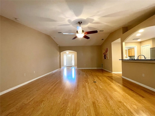 16405 SW 14th Avenue Rd, Ocala, FL 34473 - unfurnished room featuring arched walkways, lofted ceiling, ceiling fan, light wood-style flooring, and baseboards