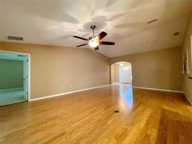 16405 SW 14th Avenue Rd, Ocala, FL 34473 - empty room with arched walkways, a ceiling fan, light wood-style floors, vaulted ceiling, and baseboards