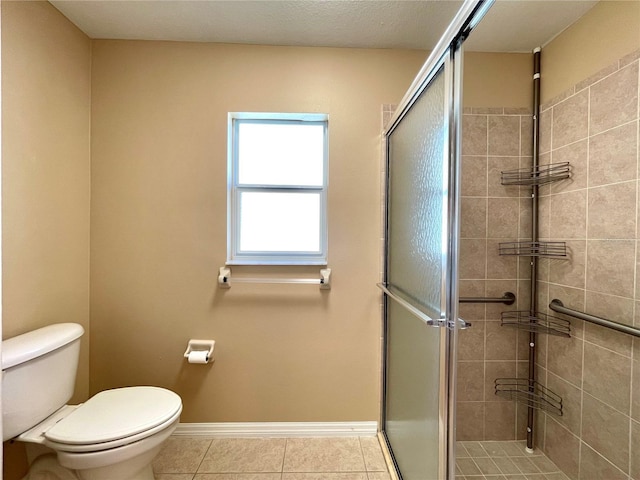 16405 SW 14th Avenue Rd, Ocala, FL 34473 - bathroom with toilet, a shower stall, tile patterned flooring, and baseboards