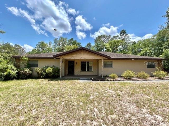 20100 SW 95th St, Dunnellon, FL 34431 - ranch-style house with a front yard and stucco siding